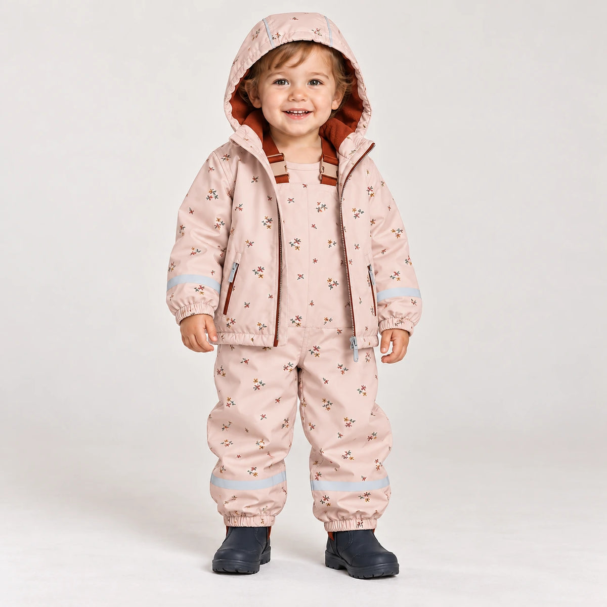 Toddler wearing HONEYKING fleece-lined rain jacket and bib rain pants in pink floral print
