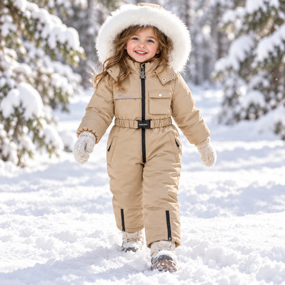 Toddler girl in beige one-piece snowsuit with faux fur hood in the snow